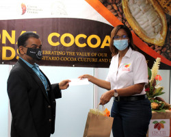 Mr. Kelvin Mahabir CEO (left) of the National Flour Mills Ltd, receives a token of appreciation from CDCTTL Marketing Manager, Ms. Gabriella Gonzales